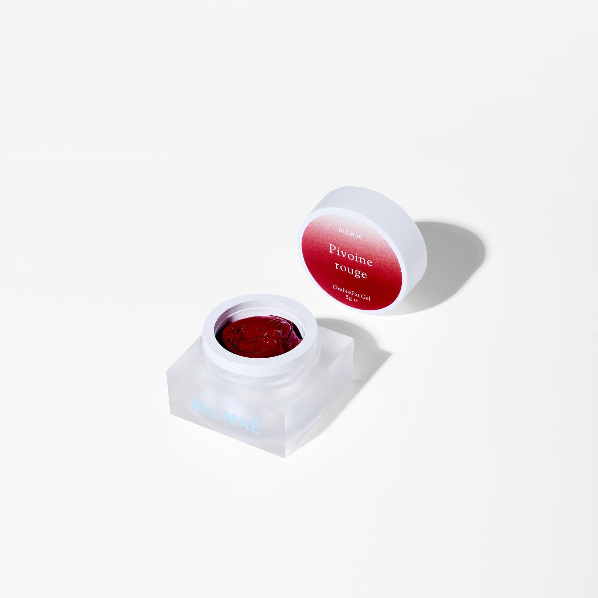 Red gel in a white container with a red lid on a white background